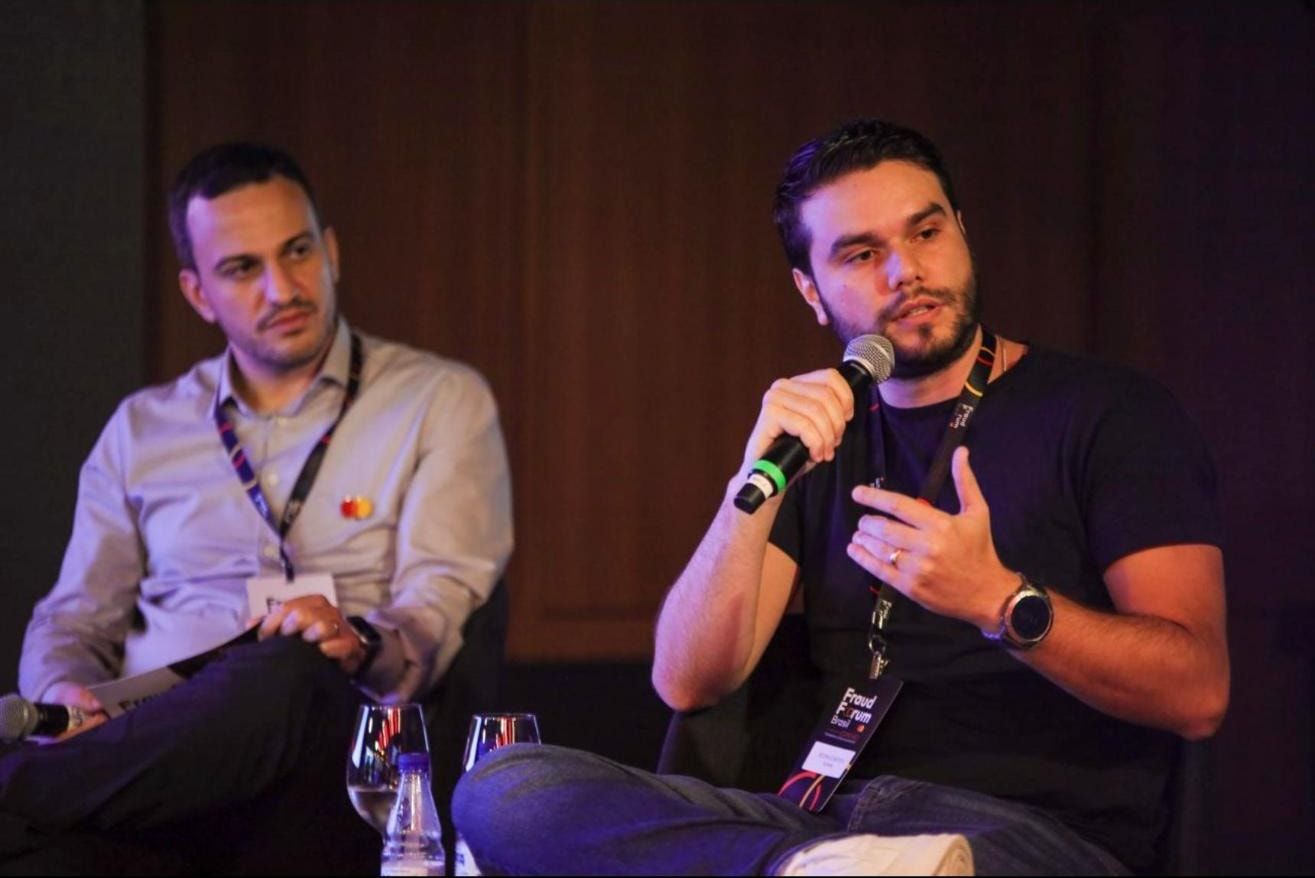 Rodrigo Monteiro falando ao microfone durante o painel sobre gestão de regras e scoring no Fraud Forum Brasil.